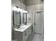 Modern bathroom featuring double sinks, white cabinets, and sleek black fixtures and fittings at 5860 Fairway View Dr, Suwanee, GA 30024