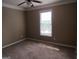 Cozy bedroom with neutral walls and carpet, featuring a window that provides natural light at 5860 Fairway View Dr, Suwanee, GA 30024