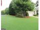 Lush front yard with mature tree shading manicured landscaping at 5860 Fairway View Dr, Suwanee, GA 30024