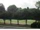 Scenic view of a green golf course framed by mature trees at 5860 Fairway View Dr, Suwanee, GA 30024