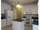 Bright kitchen with an island, black countertops, and white cabinets and appliances at 5860 Fairway View Dr, Suwanee, GA 30024