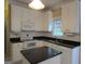 Kitchen featuring white cabinets, black countertops, and modern appliances at 5860 Fairway View Dr, Suwanee, GA 30024