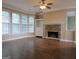 Bright living room with a stone fireplace, built-in shelving, and hardwood flooring at 5860 Fairway View Dr, Suwanee, GA 30024