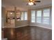 Open-concept living room with hardwood floors and a view of the kitchen with white cabinets at 5860 Fairway View Dr, Suwanee, GA 30024