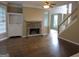 Spacious living room with a stone fireplace, built-in shelving, and staircase access at 5860 Fairway View Dr, Suwanee, GA 30024