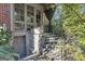 View of the home's back entrance, featuring stone steps, lush landscaping, and architectural details at 619 E Pelham Ne Rd, Atlanta, GA 30324