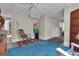 Bright basement area with a rocking chair, neutral walls, and colorful artwork at 619 E Pelham Ne Rd, Atlanta, GA 30324