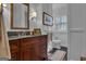 Bathroom with a dark marble countertop, dark wood cabinetry and a white toilet at 619 E Pelham Ne Rd, Atlanta, GA 30324