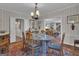 Elegant dining room with striped wallpaper, chandelier, and seating for six around a glass table at 619 E Pelham Ne Rd, Atlanta, GA 30324