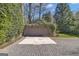 Detached garage with a paved driveway, surrounded by lush greenery and trees at 619 E Pelham Ne Rd, Atlanta, GA 30324