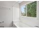 Cozy, well-lit bathroom with a tub and shower combination and a view of the outdoors at 909 Chapman Cir, Stone Mountain, GA 30088