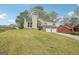 Two-story home with two-car garage and mature landscaping in neighborhood viewed from the side at 909 Chapman Cir, Stone Mountain, GA 30088