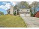 Charming two-story home featuring a two-car garage and a well-maintained front yard with mature trees at 909 Chapman Cir, Stone Mountain, GA 30088