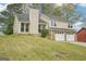 Two-story home with two-car garage and mature landscaping viewed from the side yard at 909 Chapman Cir, Stone Mountain, GA 30088