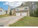 Two-story home with two-car garage and mature landscaping viewed from the side yard at 909 Chapman Cir, Stone Mountain, GA 30088