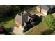 Aerial view showcases the home's roof, landscaping, driveway and surrounding neighborhood at 117 Berkeley Way, Hampton, GA 30228