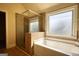 Elegant bathroom showcases a glass-enclosed shower, a luxurious bathtub, and a window for natural light at 117 Berkeley Way, Hampton, GA 30228