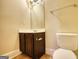 Cozy powder room with compact vanity, a matching mirror, and a standard toilet at 117 Berkeley Way, Hampton, GA 30228