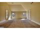 A spacious room with neutral carpet and paint, and multiple windows allowing light to flow through at 117 Berkeley Way, Hampton, GA 30228