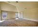 A sunlit room with neutral carpet and paint, with windows overlooking the trees outside at 117 Berkeley Way, Hampton, GA 30228