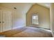 A bright bedroom with plush carpet, a window bringing in natural light, and neutral walls at 117 Berkeley Way, Hampton, GA 30228