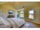 Bright bedroom featuring a large window, vaulted ceiling, a queen bed, a plant and neutral walls at 117 Berkeley Way, Hampton, GA 30228