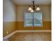 Bright dining room with chandelier, large window, and neutral tile flooring at 117 Berkeley Way, Hampton, GA 30228