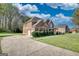 Spacious lot features a two-story brick home with an attached garage and long driveway with mature trees at 117 Berkeley Way, Hampton, GA 30228