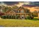 Charming two-story brick home with a welcoming front porch and manicured lawn, perfect for suburban living at 117 Berkeley Way, Hampton, GA 30228