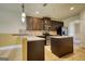 Well-lit kitchen featuring granite countertops, stainless steel appliances, and dark brown cabinetry at 117 Berkeley Way, Hampton, GA 30228