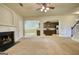 Open-concept living room with fireplace and view of kitchen and staircase at 117 Berkeley Way, Hampton, GA 30228