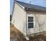 Home exterior featuring light beige siding and a dark grey roof against a cloudy blue sky at 1354 Persimmon Ct, Lithonia, GA 30058