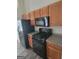 Kitchen boasts modern black appliances and wood cabinetry, offering ample storage at 1354 Persimmon Ct, Lithonia, GA 30058