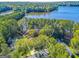 Aerial view of a lakefront property showcasing the home's location amidst lush greenery and a serene lake at 504 Telfair Park, Peachtree City, GA 30269