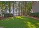Green lawn stretches towards lakefront, framed by mature trees, creating a private oasis at 504 Telfair Park, Peachtree City, GA 30269