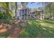 Expansive backyard featuring a charming pond, lush greenery, and a home with multiple screened porches at 504 Telfair Park, Peachtree City, GA 30269