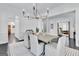 Bright dining room with modern chandelier, gray table with seating for six and plenty of natural light at 504 Telfair Park, Peachtree City, GA 30269