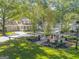 Beautifully landscaped front yard with lush green grass, mature trees, and a charming pergola at 504 Telfair Park, Peachtree City, GA 30269