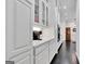 Bright, all-white kitchen with quartz counters, glass-front cabinets, and stainless steel appliances at 504 Telfair Park, Peachtree City, GA 30269