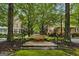 Quaint street scene featuring townhomes set behind mature trees, enhancing neighborhood charm at 504 Telfair Park, Peachtree City, GA 30269
