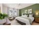 Bright main bedroom featuring a green accent wall, large windows, and modern furnishings at 566 Silver Moon Drive # 21, Loganville, GA 30052