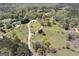 Aerial view of property featuring two-story home, green lawn, mature trees, and winding driveway at 935 Amelia Rd, Locust Grove, GA 30248