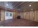 Spacious basement with wood paneled walls, brick flooring, and a door leading to the exterior at 935 Amelia Rd, Locust Grove, GA 30248