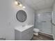 Bathroom featuring a shower with glass doors, vanity, toilet and a round mirror at 935 Amelia Rd, Locust Grove, GA 30248