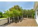 Expansive wooden deck with black railings overlooks a lush green backyard with mature trees at 935 Amelia Rd, Locust Grove, GA 30248