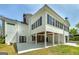 Exterior view of a spacious home, showcasing large windows, covered patio and yard at 935 Amelia Rd, Locust Grove, GA 30248