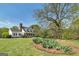 Exterior view of a two-story white home with a black roof, landscaping, and a large lawn at 935 Amelia Rd, Locust Grove, GA 30248