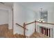 Well-lit upstairs landing with hardwood floors and a decorative chandelier at 935 Amelia Rd, Locust Grove, GA 30248