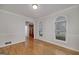 Bright room with hardwood floors, windows, and door leading to a hall and exterior view at 935 Amelia Rd, Locust Grove, GA 30248