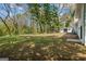Spacious backyard with mature trees, a building, and a glimpse of the home's exterior at 1146 Redan Way, Stone Mountain, GA 30088